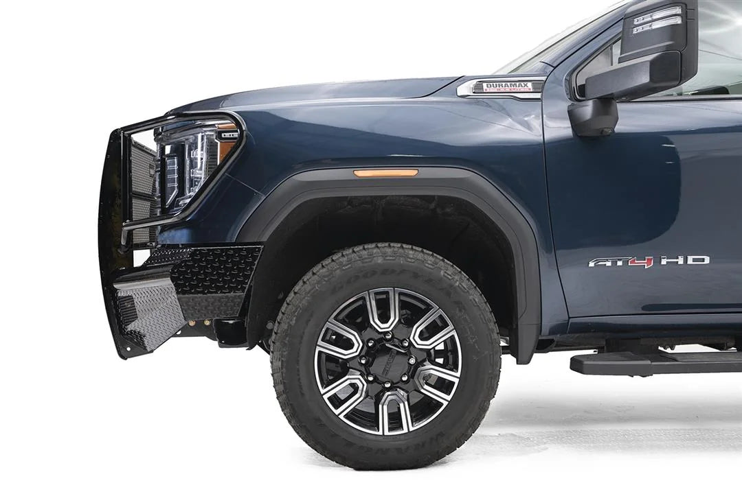 Fab Fours Black Steel front bumper with full guard on a blue GMC Sierra 2500HD/3500HD, close-up of the front corner, showing full guard side hoop, diamond-plate end, wheel-well clearance