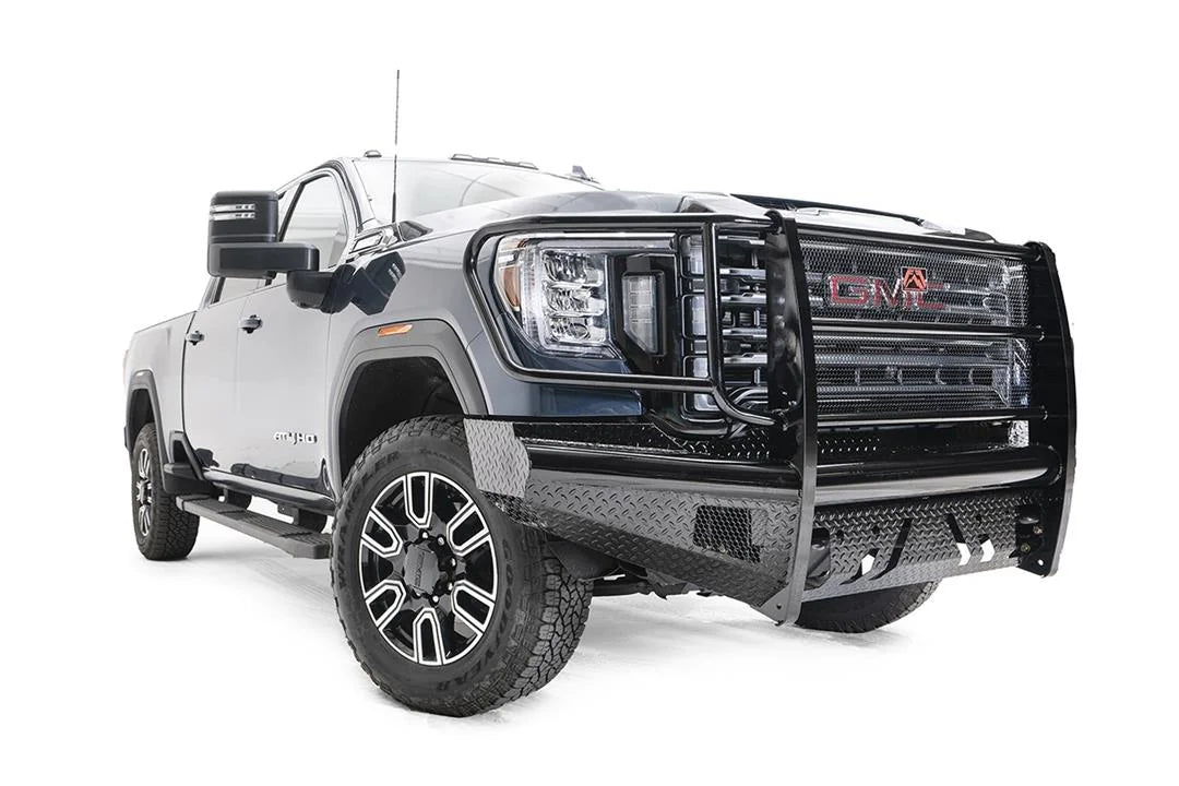 Fab Fours Black Steel front bumper with full guard on a blue GMC Sierra 2500HD/3500HD, front passenger-side three-quarter view, showing full grille guard, diamond-plate finish, mesh end inserts