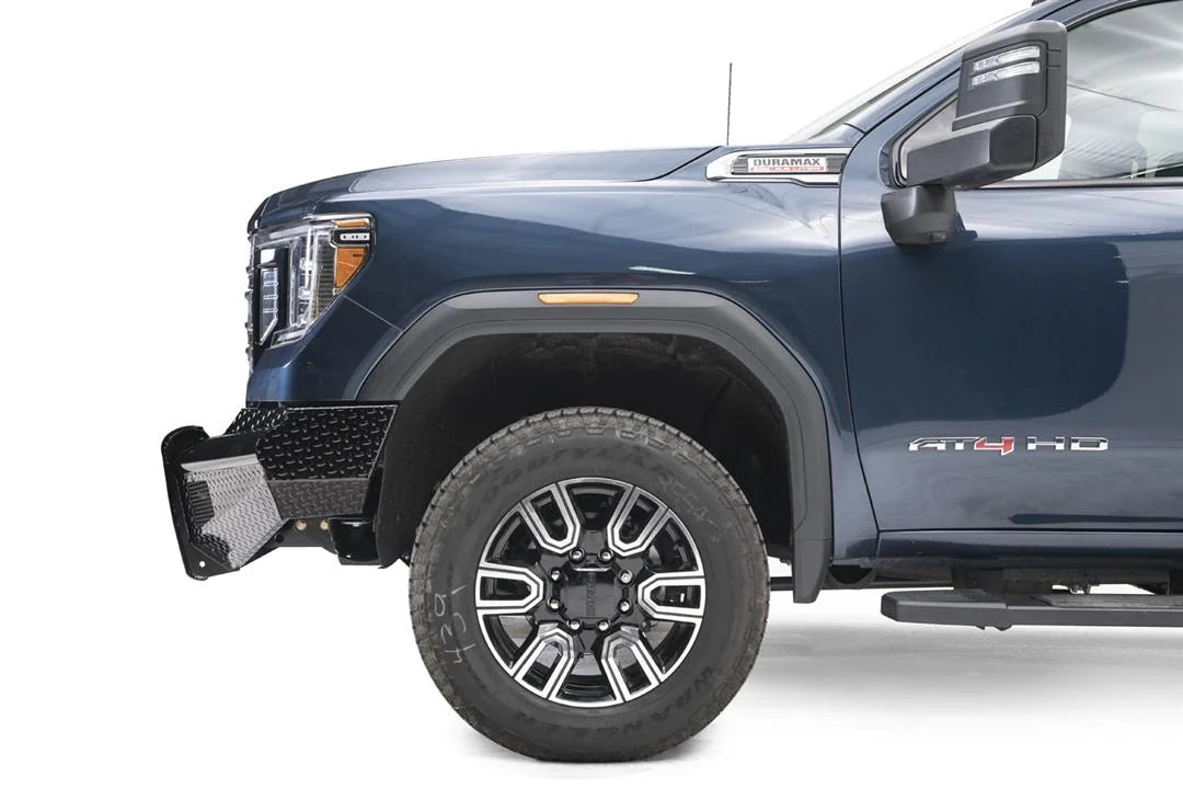 Fab Fours Black Steel front bumper on a blue GMC Sierra 2500HD/3500HD, close-up of the front corner, showing diamond-plate end, top tube, wheel-well clearance