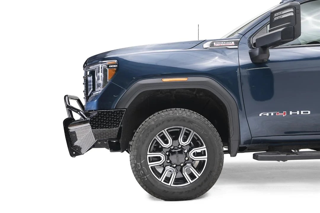 Fab Fours Black Steel front bumper with pre-runner guard on a blue GMC Sierra 2500HD/3500HD, close-up of the front corner, showing pre-runner hoop, diamond-plate end, wheel-well clearance