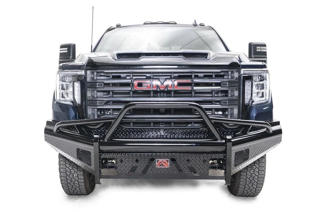 Fab Fours Black Steel front bumper with pre-runner guard on a blue GMC Sierra 2500HD/3500HD, straight-on front view, showing pre-runner hoop, diamond-plate finish, mesh end inserts, Fab Fours badge