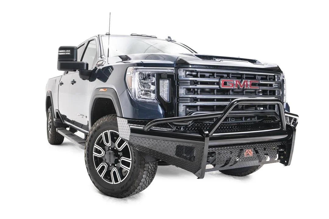 Fab Fours Black Steel front bumper with pre-runner guard on a blue GMC Sierra 2500HD/3500HD, front passenger-side three-quarter view, showing pre-runner hoop, diamond-plate finish, mesh end inserts, Fab Fours badge