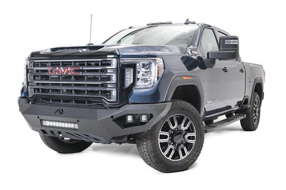 Fab Fours Vengeance front bumper on a blue GMC Sierra 2500HD/3500HD, front driver-side three-quarter view, showing integrated light bar, cube light pods, angular skid plate