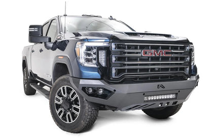 Fab Fours Vengeance front bumper on a blue GMC Sierra 2500HD/3500HD, front passenger-side three-quarter view, showing integrated light bar, cube light pods, angular skid plate