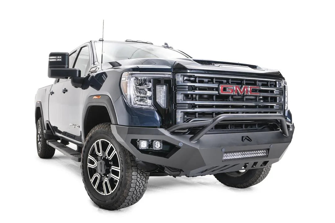 Fab Fours Vengeance front bumper with pre-runner guard on a blue GMC Sierra 2500HD/3500HD, front passenger-side three-quarter view, showing pre-runner hoop, integrated light bar, cube light pods, angular skid plate