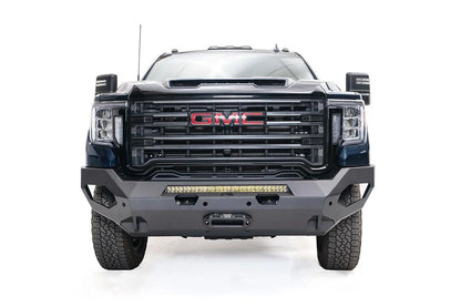 Fab Fours Matrix front bumper on a blue GMC Sierra 2500HD/3500HD, straight-on front view, showing integrated light bar, winch-ready center, cube light pods