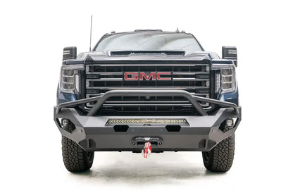 Fab Fours Matrix front bumper with pre-runner guard on a blue GMC Sierra 2500HD/3500HD, straight-on front view, showing pre-runner hoop, integrated light bar, winch-ready center