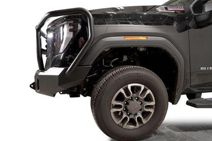 Fab Fours Premium Winch front bumper with full guard on a black GMC Sierra 2500HD/3500HD, close-up of the front corner, showing full guard side hoop, bumper end cap, wheel-well clearance