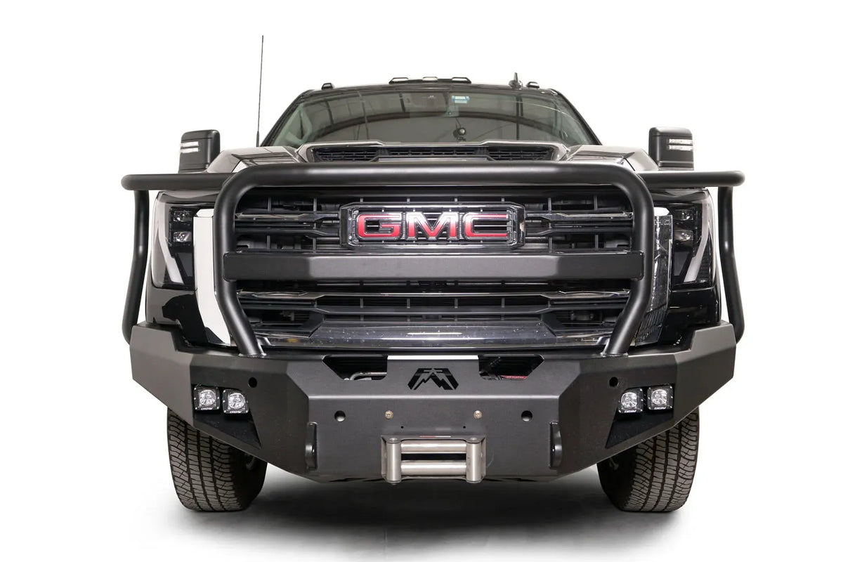Fab Fours Premium Winch front bumper with full guard on a black GMC Sierra 2500HD/3500HD, straight-on front view, showing full guard hoop, winch mount, cube light pods, angled end caps