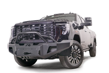 Fab Fours Premium Winch front bumper with pre-runner guard on a black GMC Sierra 2500HD/3500HD, front driver-side three-quarter view, showing pre-runner hoop, winch mount opening, angled end caps