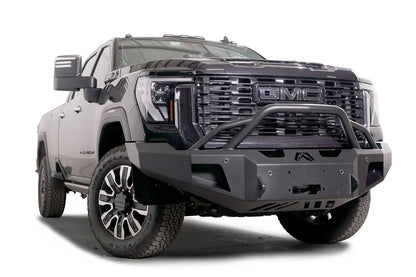 Fab Fours Premium Winch front bumper with pre-runner guard on a black GMC Sierra 2500HD/3500HD, front passenger-side three-quarter view, showing pre-runner hoop, winch mount opening, angled end caps