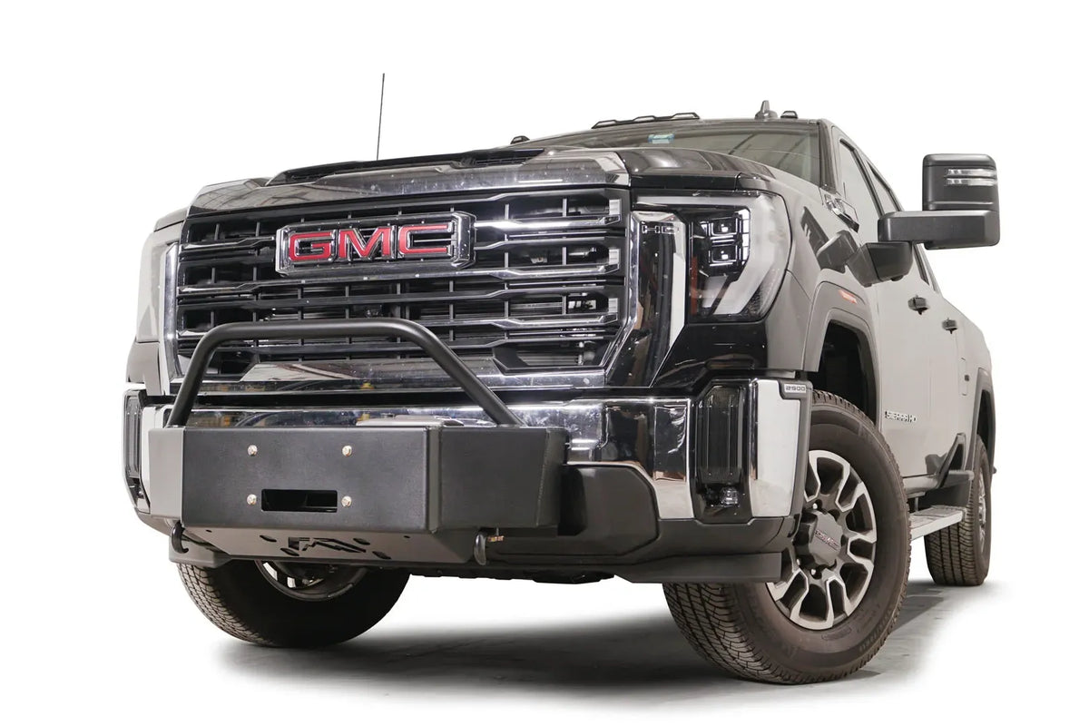 Fab Fours winch mount with pre-runner guard on a black GMC Sierra 2500HD/3500HD, front driver-side three-quarter view, showing pre-runner hoop, winch plate, factory bumper integration