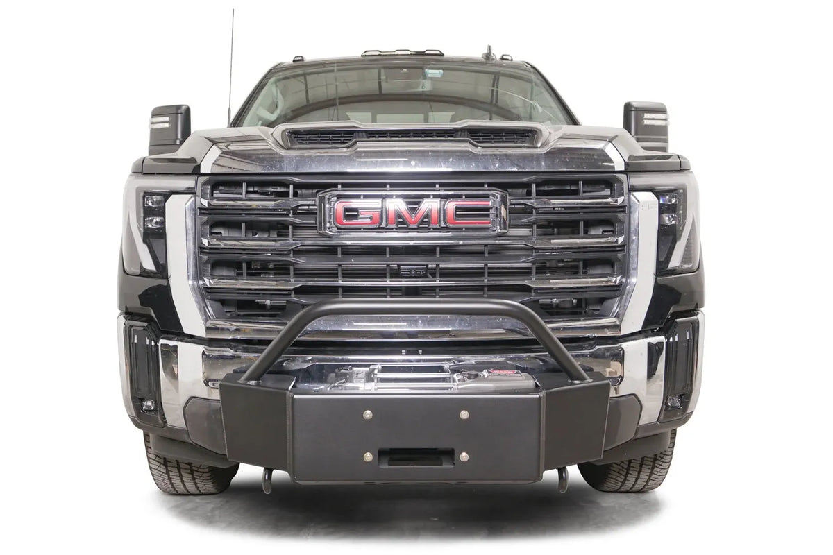 Fab Fours winch mount with pre-runner guard on a black GMC Sierra 2500HD/3500HD, straight-on front view, showing pre-runner hoop, winch plate, factory bumper integration