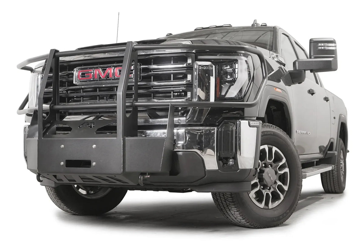 Fab Fours winch mount with full guard on a black GMC Sierra 2500HD/3500HD, front driver-side three-quarter view, showing full guard uprights, wraparound headlight hoops, winch plate