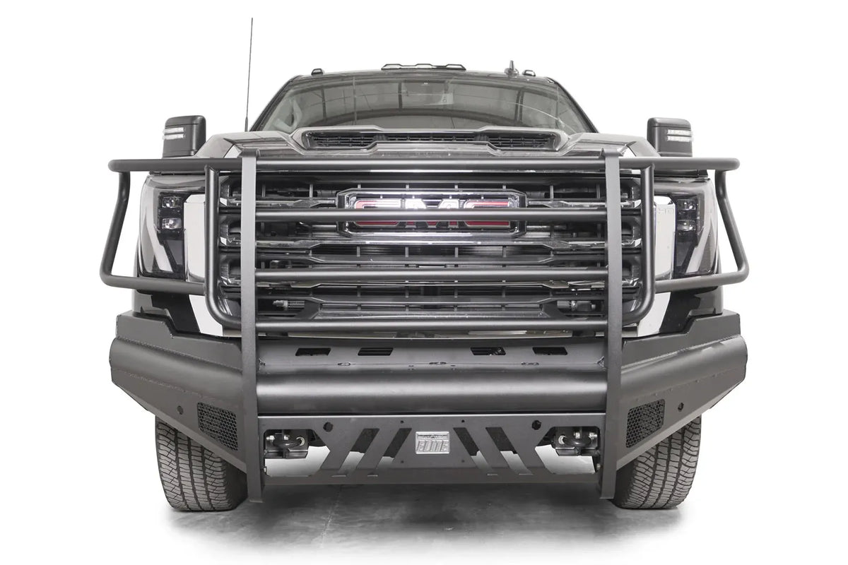Fab Fours Black Steel Elite front bumper with full guard on a black GMC Sierra 2500HD/3500HD, straight-on front view, showing full grille guard, Elite badge, slotted skid plate, mesh end inserts