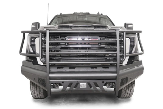 Fab Fours Black Steel Elite front bumper with full guard on a black GMC Sierra 2500HD/3500HD, straight-on front view, showing full grille guard, Elite badge, slotted skid plate, mesh end inserts