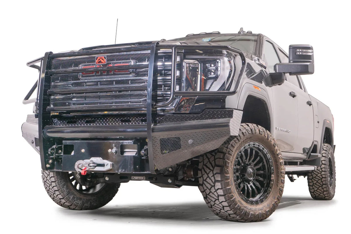 Fab Fours Black Steel front bumper with full guard on a black GMC Sierra 2500HD/3500HD, front driver-side three-quarter view, showing full grille guard, diamond-plate finish, mesh end inserts, winch