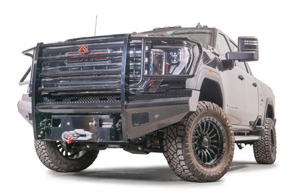 Fab Fours Black Steel front bumper with full guard on a black GMC Sierra 2500HD/3500HD, front driver-side three-quarter view, showing full grille guard, diamond-plate finish, mesh end inserts, winch