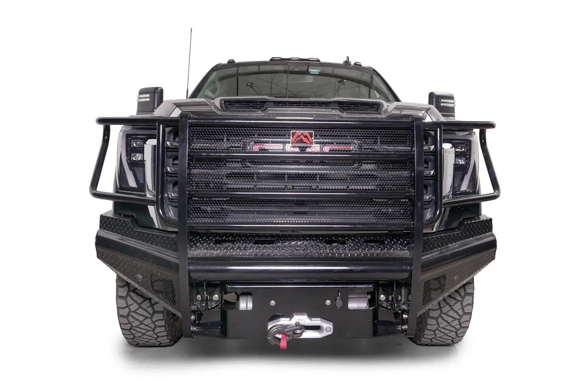 Fab Fours Black Steel front bumper with full guard on a black GMC Sierra 2500HD/3500HD, straight-on front view, showing full grille guard, diamond-plate finish, mesh end inserts, winch
