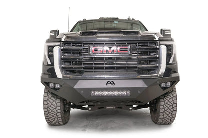 Fab Fours Vengeance front bumper on a black GMC Sierra 2500HD/3500HD, straight-on front view, showing integrated light bar, cube light pods, angular skid plate