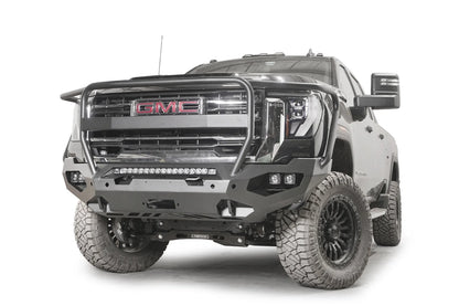 Fab Fours Matrix front bumper with full guard on a dark gray GMC Sierra 2500HD/3500HD, front driver-side three-quarter view, showing full guard hoop, integrated light bar, cube light pods