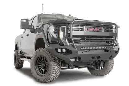 Fab Fours Matrix front bumper with full guard on a dark gray GMC Sierra 2500HD/3500HD, front passenger-side three-quarter view, showing full guard hoop, integrated light bar, cube light pods