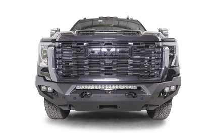 Fab Fours Matrix front bumper on a dark gray GMC Sierra 2500HD/3500HD, straight-on front view, showing integrated light bar, cube light pods, winch-ready center