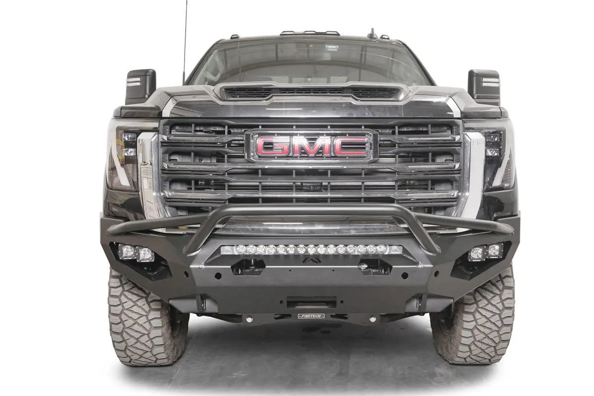 Fab Fours Matrix front bumper with pre-runner guard on a black GMC Sierra 2500HD/3500HD, straight-on front view, showing pre-runner hoop, integrated light bar, cube light pods