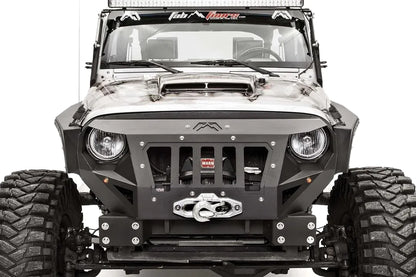 Fab Fours Grumper front bumper in Stubby configuration on a gray Jeep Wrangler JK, close-up of the front corner, showing grille-integrated design, winch and fairlead, bolted plate construction