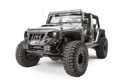 Fab Fours Grumper front bumper in Stubby configuration on a gray Jeep Wrangler JK, front driver-side three-quarter view, showing grille-integrated design, winch housing, round headlight openings