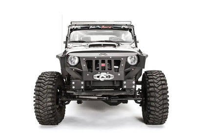 Fab Fours Grumper front bumper in Stubby configuration on a gray Jeep Wrangler JK, straight-on front view, showing grille-integrated design, winch housing, round headlight openings
