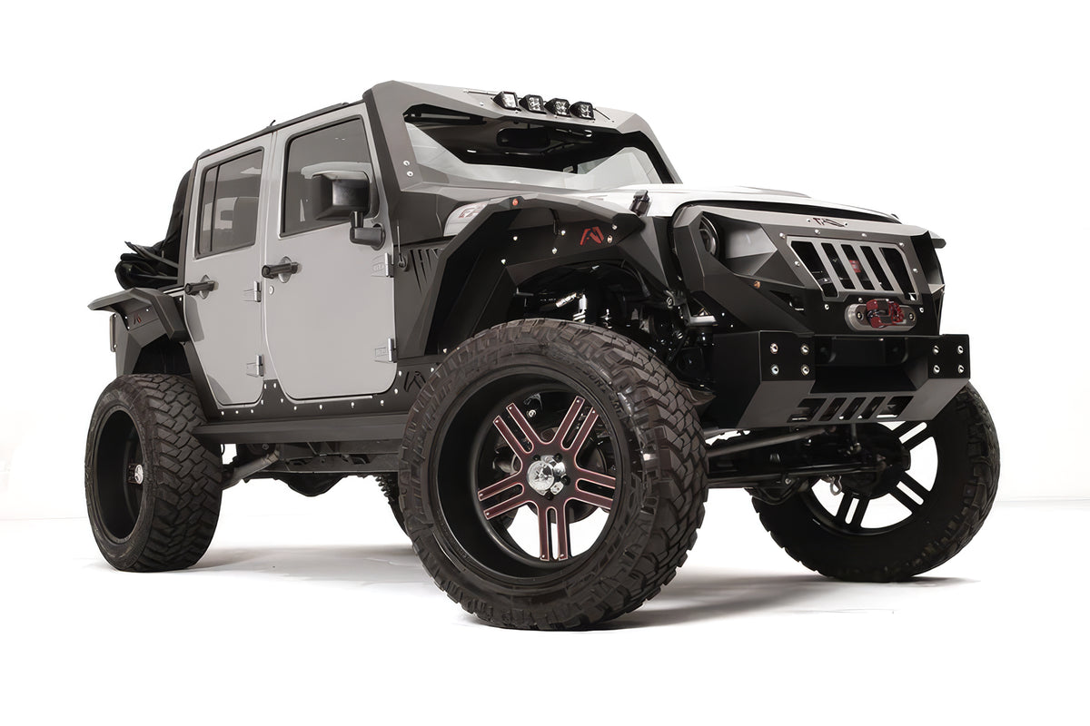 Fab Fours Grumper crash bar with slotted grille on a lifted gray Jeep Wrangler JK Unlimited, passenger-side front three-quarter view, with winch and Fab Fours fender flares