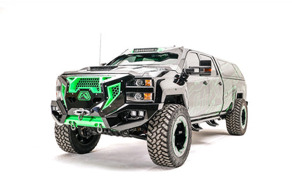 Fab Fours Grumper front bumper with green honeycomb mesh grille on a lifted black Chevrolet Silverado 2500HD with green Fab Fours graphics, driver-side front three-quarter view, with winch and cube lights