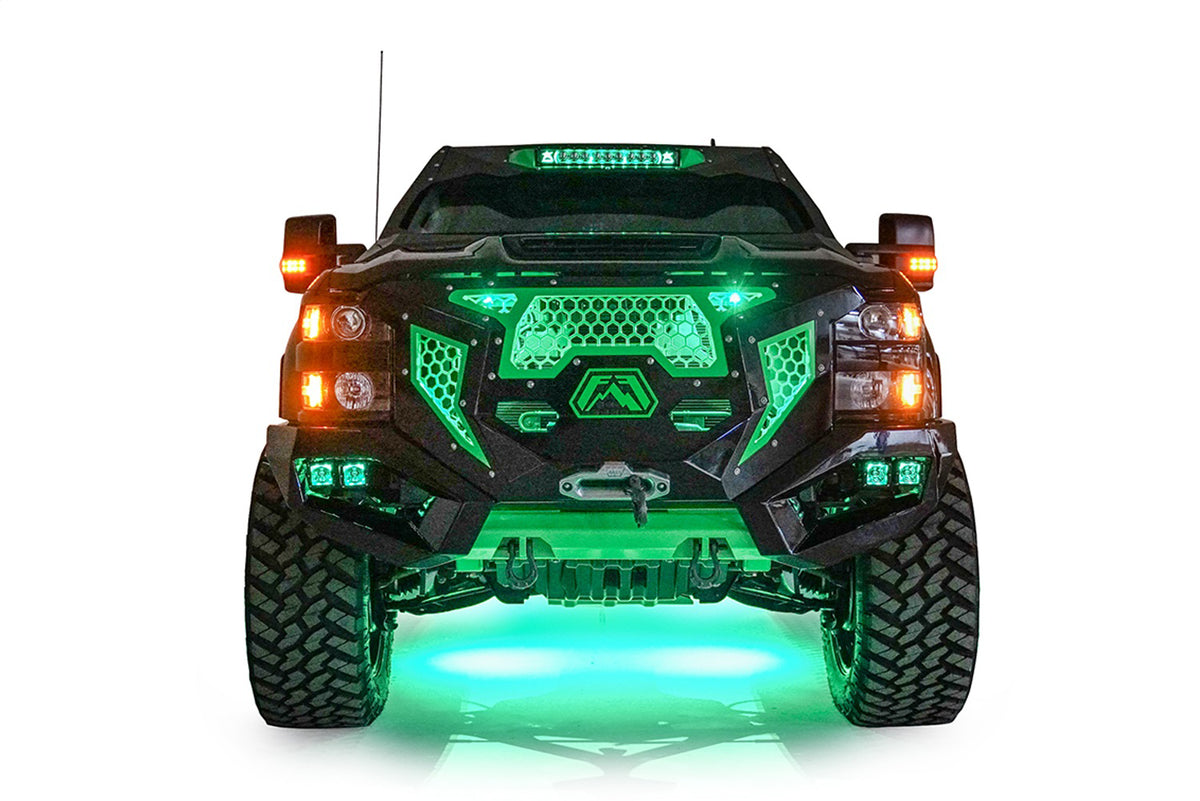 Fab Fours Grumper front bumper on a lifted black Chevrolet Silverado 2500HD, front view, with green accent lighting, illuminated cube lights, and green underglow