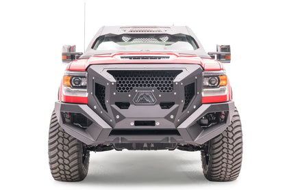 Fab Fours Grumper front bumper on a lifted red GMC Sierra 3500HD, front view, with honeycomb mesh grille, Fab Fours logo plate, and winch opening
