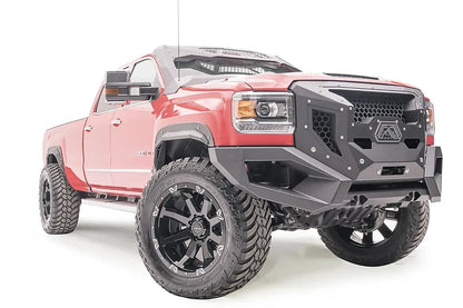Fab Fours Grumper front bumper with honeycomb mesh grille on a lifted red GMC Sierra 3500HD, passenger-side front three-quarter view, with Fab Fours fender flares