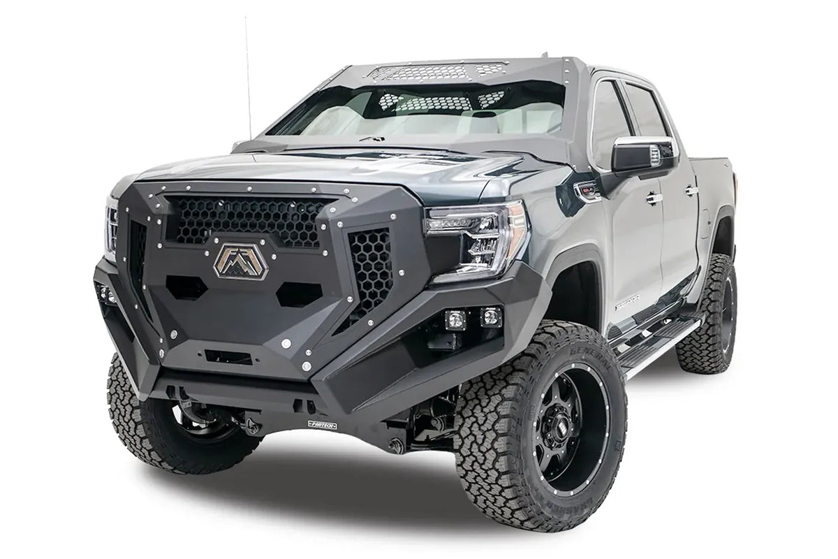 Fab Fours Grumper front bumper and grille with honeycomb mesh on a lifted gray GMC Sierra 1500, driver-side front three-quarter view, with dual cube lights