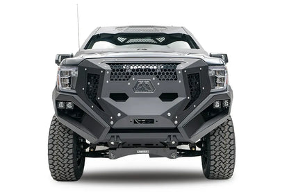 Fab Fours Grumper front bumper and grille on a lifted gray GMC Sierra 1500, front view, with honeycomb mesh, Fab Fours logo plate, and dual cube lights in each corner