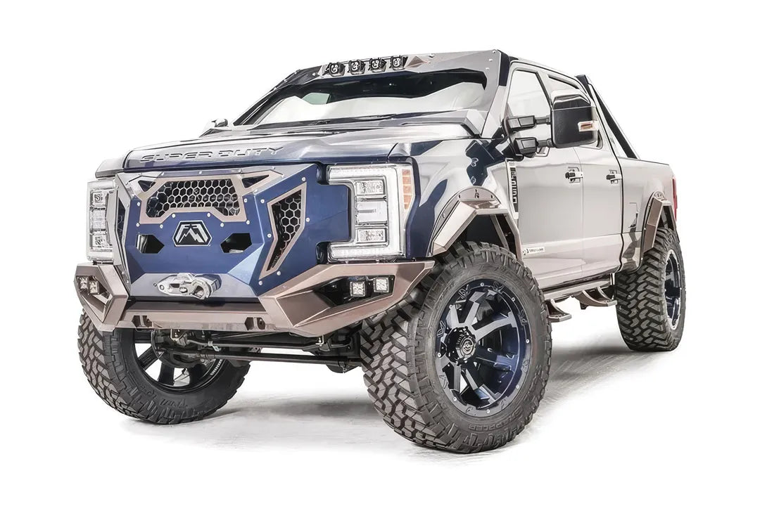 Fab Fours Grumper front bumper with blue grille panel and bronze bumper on a lifted Ford Super Duty, driver-side front three-quarter view, with cube lights