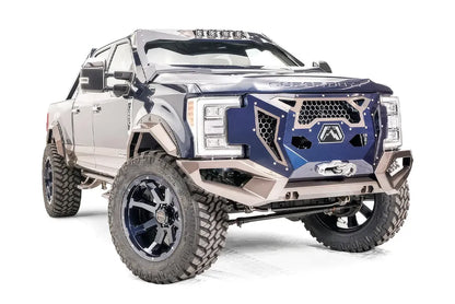 Fab Fours Grumper front bumper with blue grille panel and bronze bumper on a lifted Ford Super Duty, passenger-side front three-quarter view