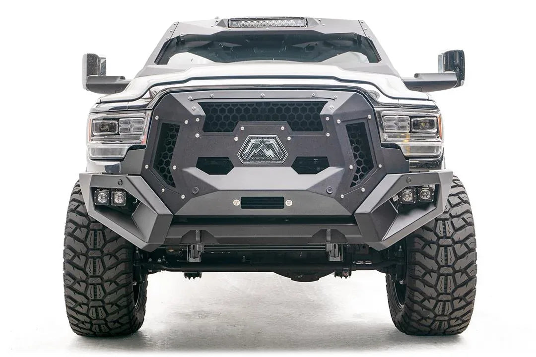 Fab Fours Grumper crash bar on a lifted white Ram 2500, front view, with honeycomb mesh grille panels, Fab Fours logo plate, and dual cube lights in each bumper corner