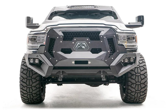 Fab Fours Grumper crash bar on a lifted white Ram 2500, front view, with honeycomb mesh grille panels, Fab Fours logo plate, and dual cube lights in each bumper corner
