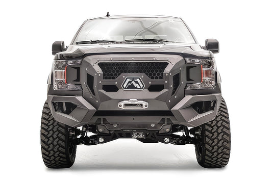 Fab Fours Grumper front winch bumper on a lifted black Ford F-150, front view, with honeycomb mesh grille, Fab Fours logo plate, and winch fairlead