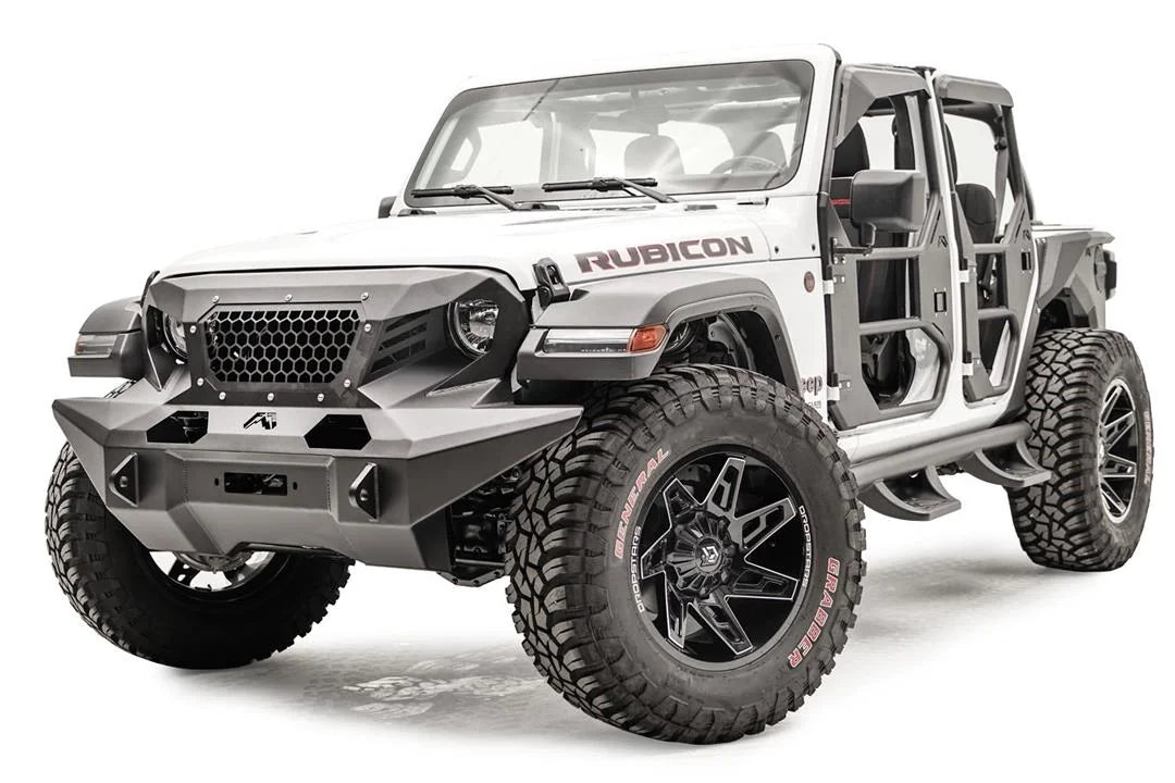 Fab Fours full-width Grumper front bumper on a lifted white Jeep Wrangler JL Rubicon, front driver-side view, showing the wide bumper wings, honeycomb mesh grille guard and Fab Fours tube doors