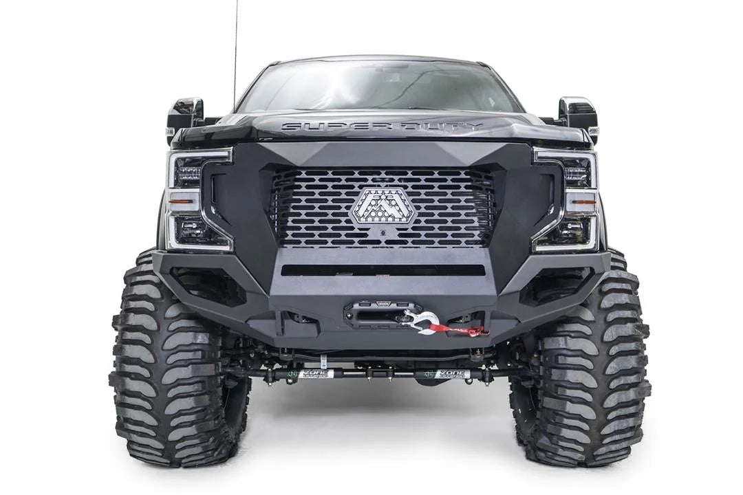 Fab Fours Grumper front winch bumper on a lifted black Ford F-250 Super Duty, front view, with mesh grille, Fab Fours logo plate, and Warn winch