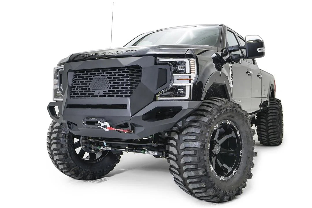 Fab Fours Grumper front winch bumper on a lifted black Ford F-250 Super Duty, driver-side front three-quarter view, with Warn winch and Fab Fours fender flares