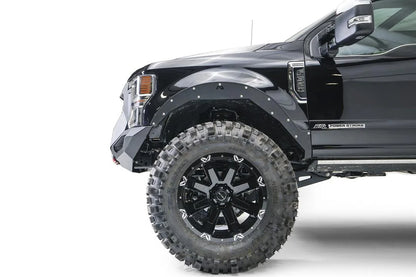Fab Fours Grumper front winch bumper on a lifted black Ford F-250 Super Duty, driver-side profile view of the bumper end and front wheel