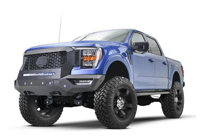 Fab Fours Grumper front bumper and grille with mesh grille and LED light bar on a lifted blue Ford F-150, driver-side front three-quarter view