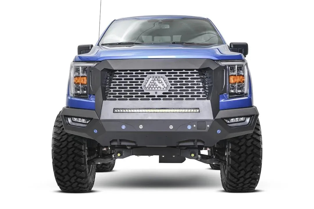 Fab Fours Grumper front bumper and grille on a lifted blue Ford F-150, front view, with mesh grille, Fab Fours logo plate, and LED light bar