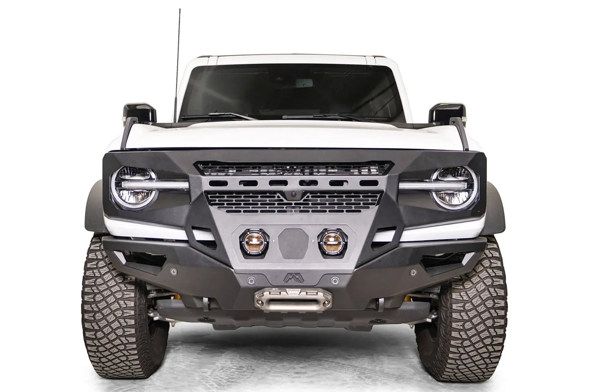 Fab Fours Grumper front bumper on a white Ford Bronco, front view, with two center pod lights and winch fairlead